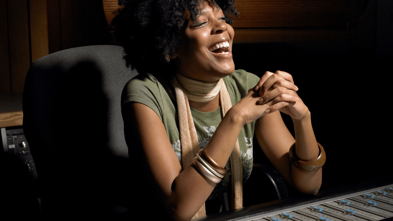 A music producer working with an artist in a recording studio