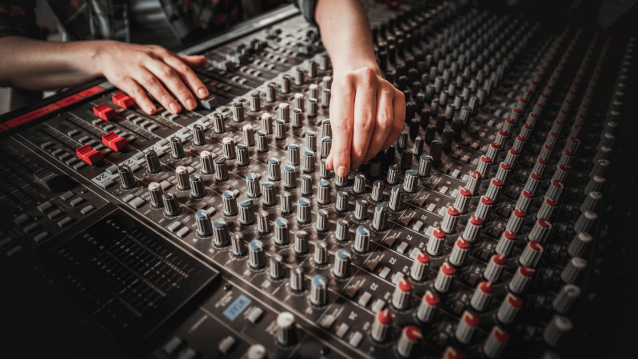 A music producer balancing tracks while mixing a song and beat.