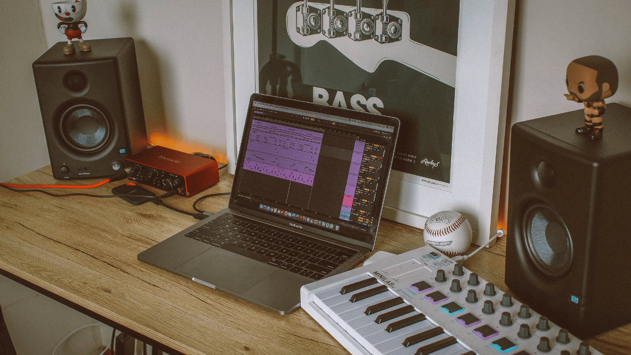A music producer makes beats with Ableton Live on a laptop in home studio.